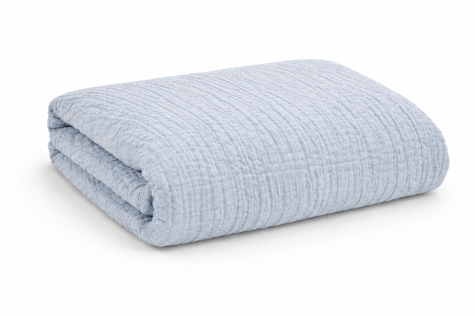 Folded pastel blue cotton bedspread on white background